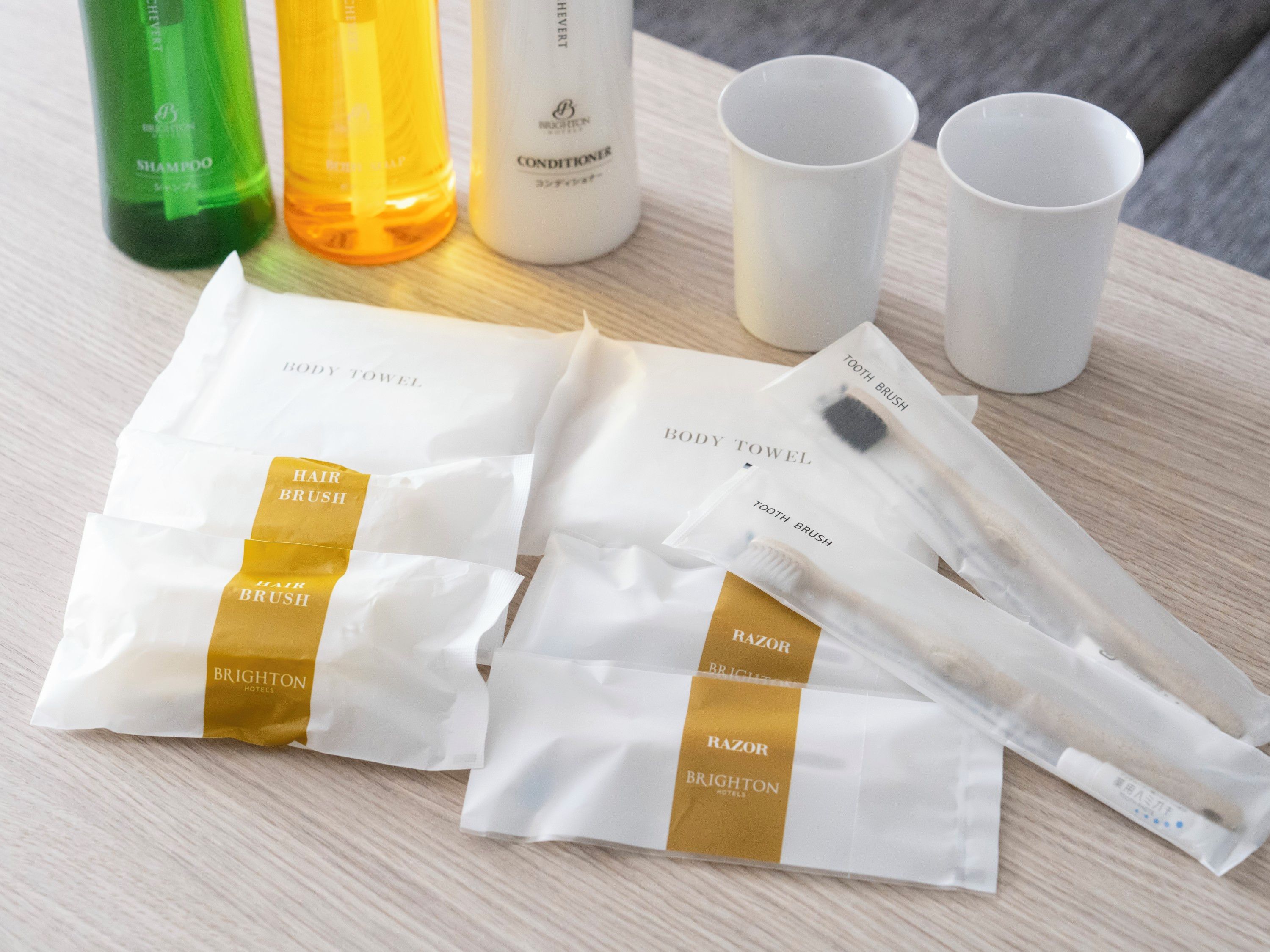 Productes de tocador com xampú, condicionador, raspall per pentinar, rasuradora i tovalló de bany.