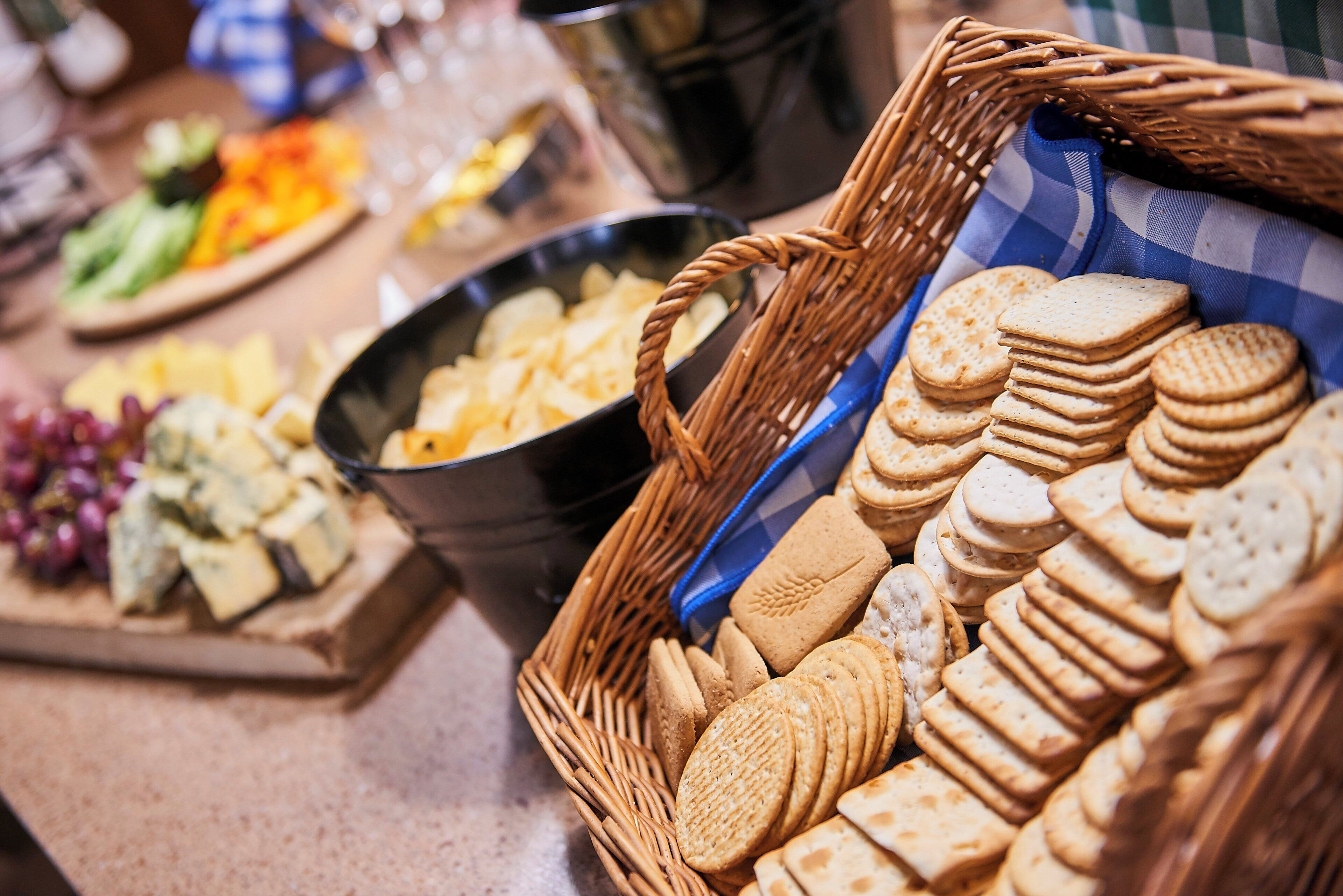 A buffet table with various food items including cheese, crackers, and fruits.