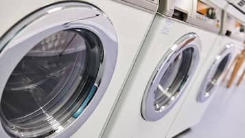 A row of front-loading washing machines in a commercial setting.