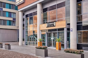 A modern hotel entrance with Staybridge Suites signage, large windows, and potted plants. - Staybridge Suites Liverpool by IHG (Liverpool)