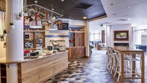 A modern kitchen with wooden countertops, hanging pots, and a hexagonal patterned floor.