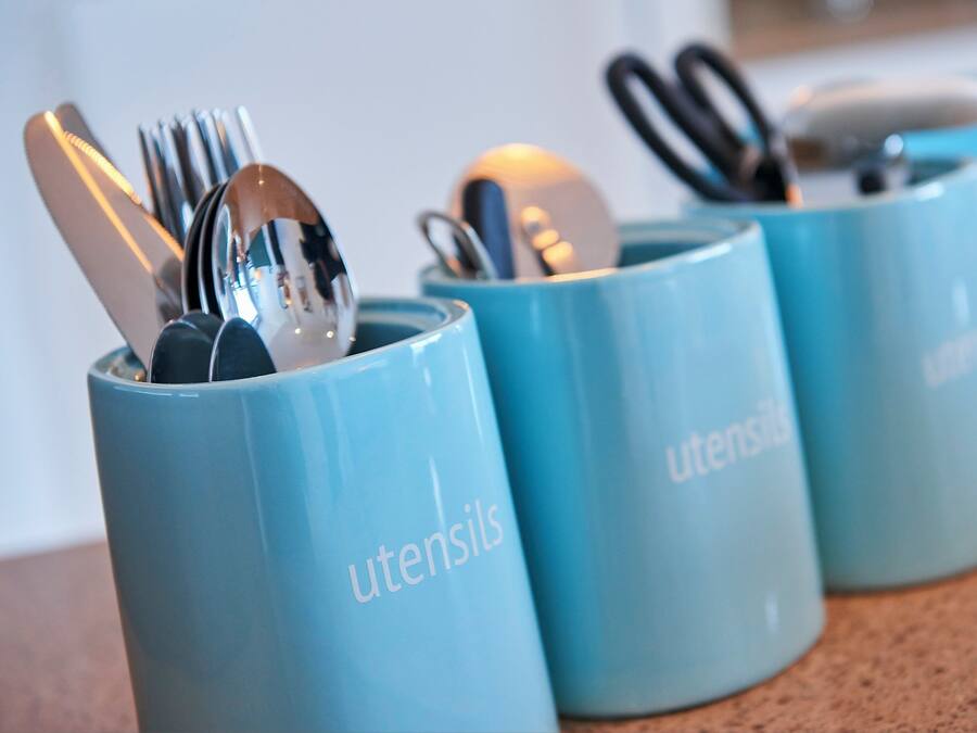 Three blue containers with utensils inside, labeled 'utensils.'