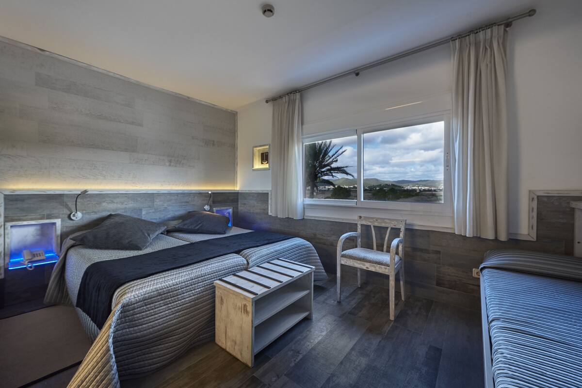 Una camera da letto moderna con un letto grande, comodini, una sedia e una finestra con vista.
