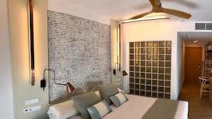 A modern hotel room with a large bed, a patterned wall, and a view of the interior. - Hotel Lux isla (Ibiza Town)