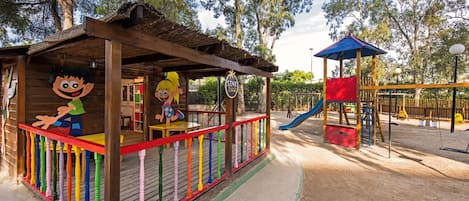 A children's play area with a wooden structure, colorful railings, and a slide.