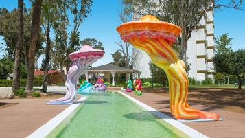 A pool area with colorful mushroom-shaped sculptures and a gazebo in the background.