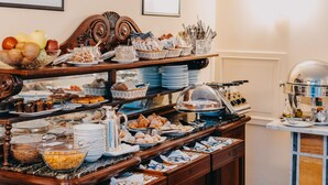 A buffet with various food items and utensils. - Costantinopoli 104 (Naples)
