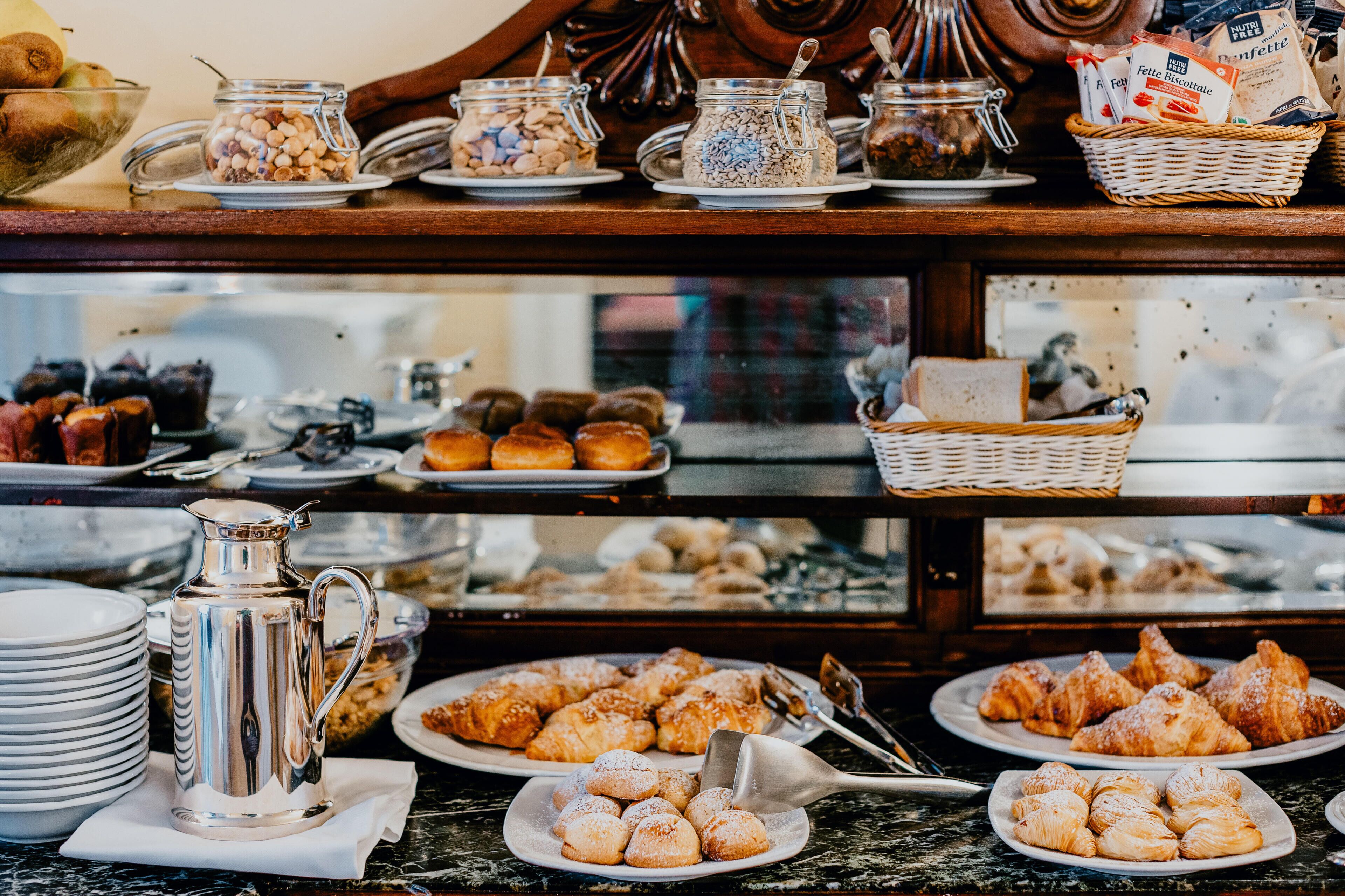 A buffet with various food items, including pastries and condiments.