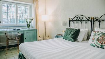 Un dormitorio con cama, escritorio, silla, lámpara y ventana con cortinas.