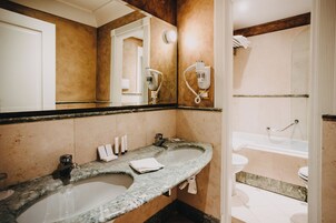 Un bagno con doppio lavandino, specchio, porta asciugamani e zona doccia.