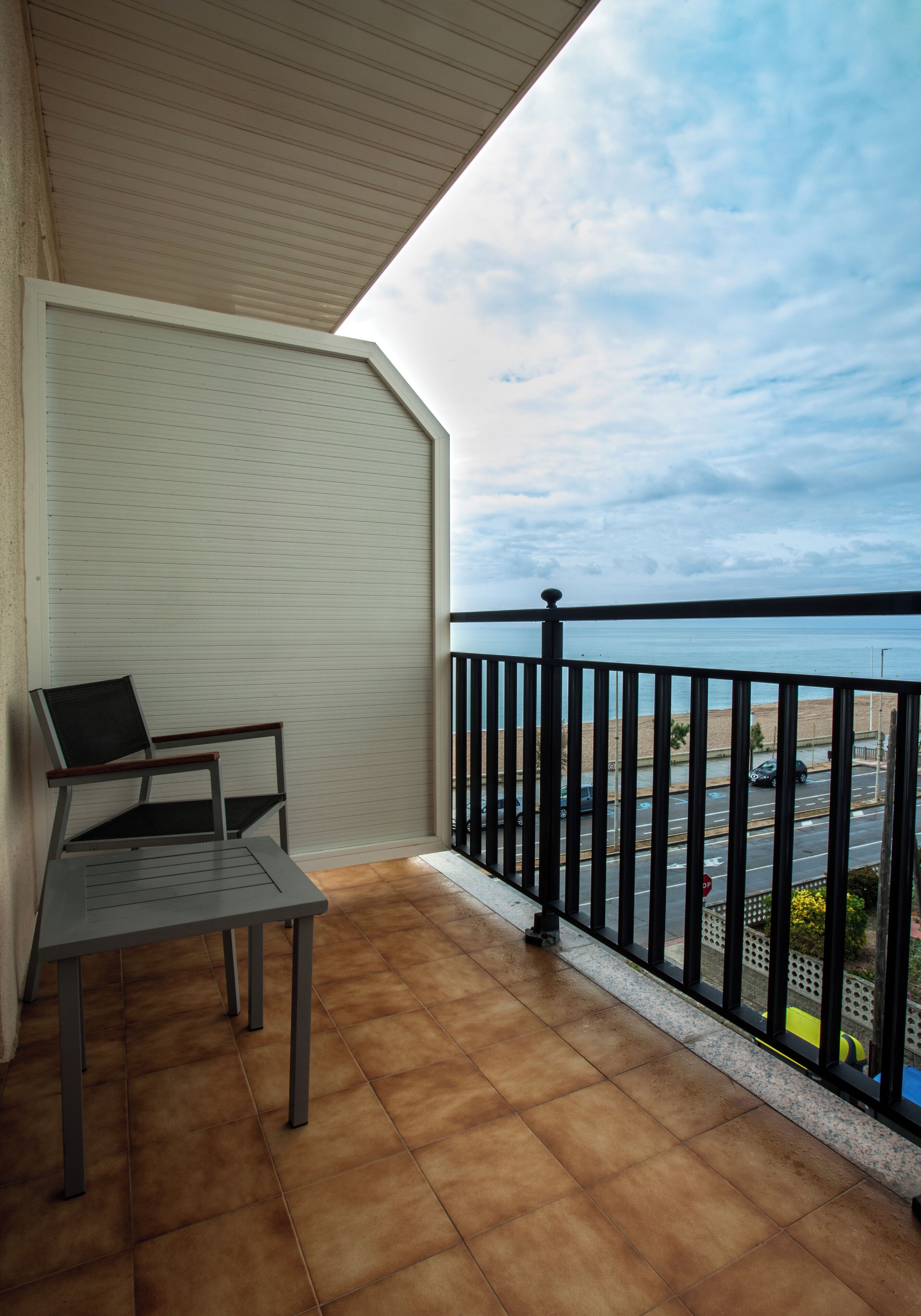Ein Balkon mit Meerblick, einem Stuhl und einem Tisch.