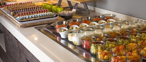 A buffet with various food items and condiments.
