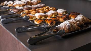 Una mesa de buffet con diversos pasteles y unas pinzas.
