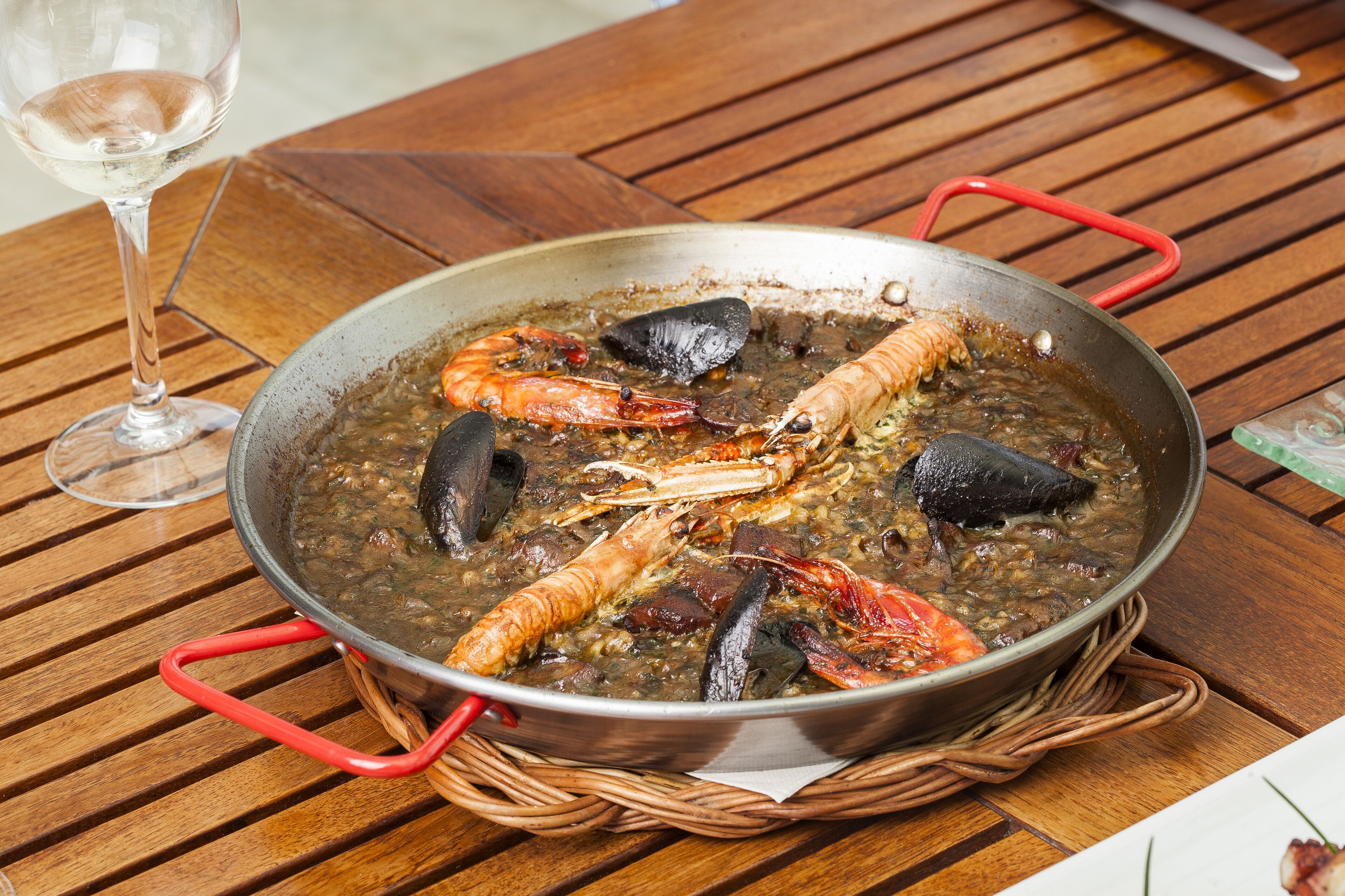 A seafood dish in a pan on a wooden table.