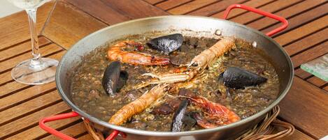 A seafood dish in a pan on a wooden table.