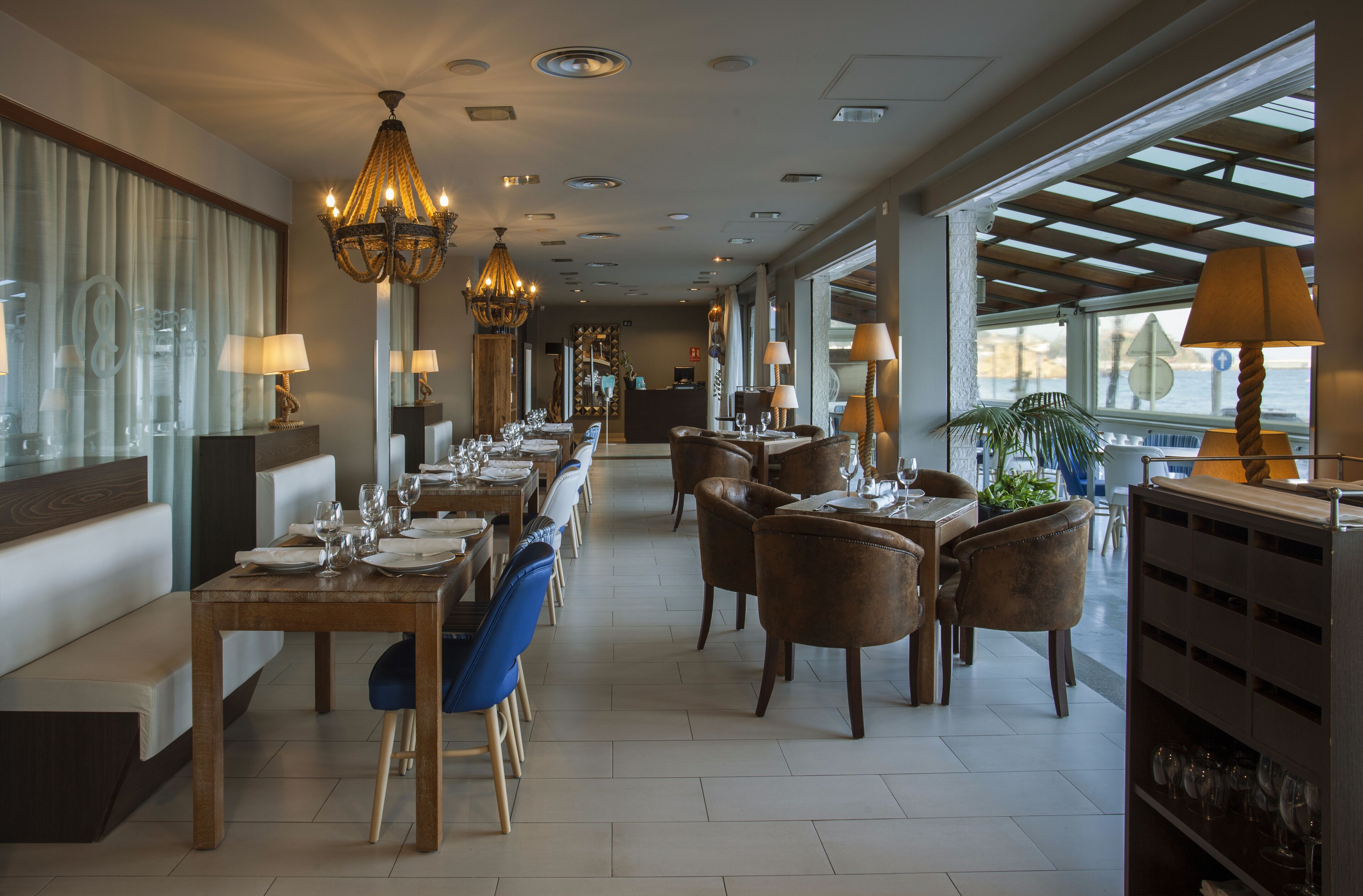 Ein geräumiges Restaurant mit langen Tischen, Stühlen und einer Kristallleuchter.