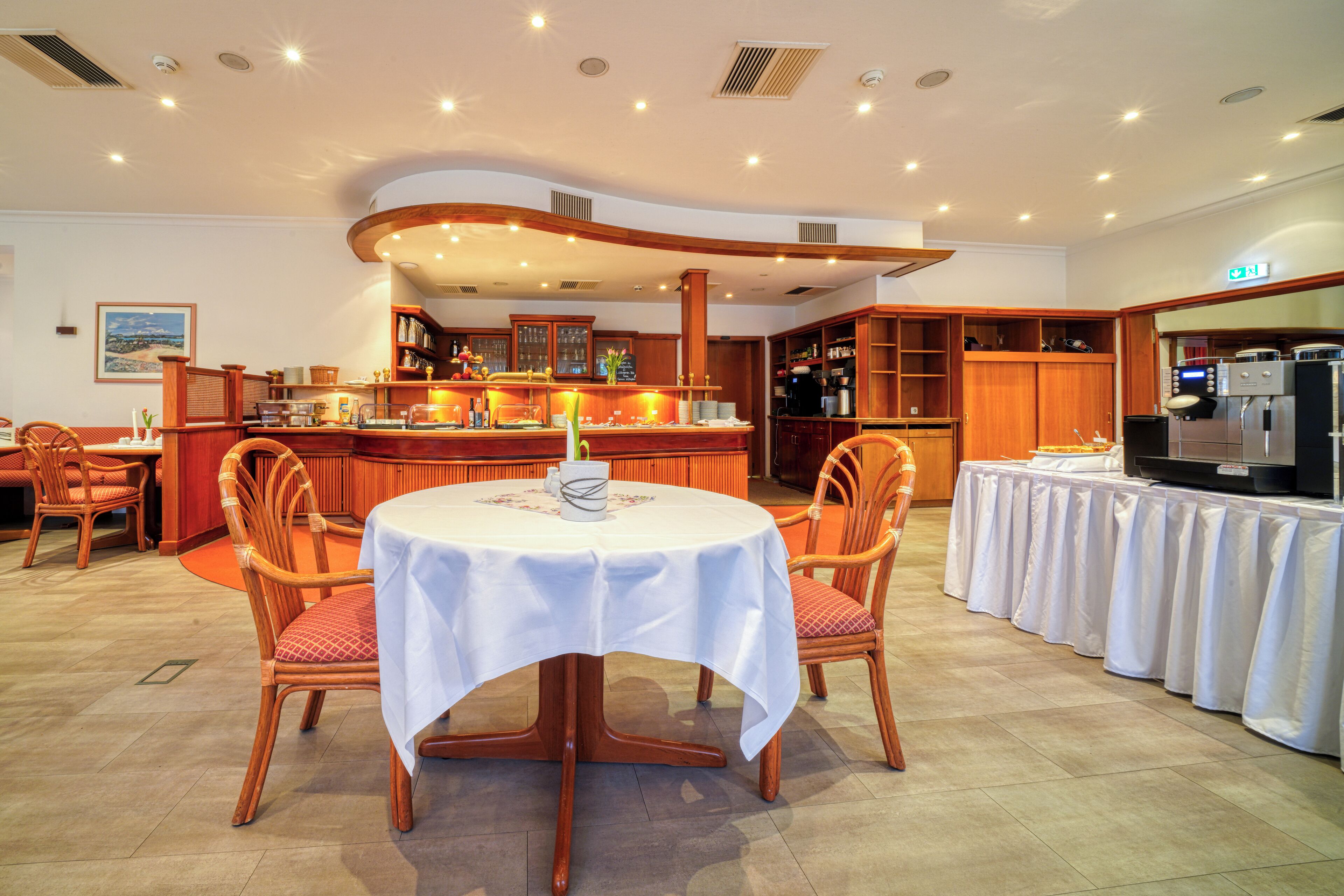 Un espace repas comprenant une table ronde, des chaises, un bar et des meubles de cuisine.