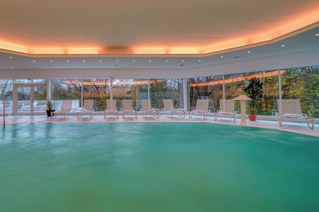 Una piscina techada, sillones reclinables de piscina