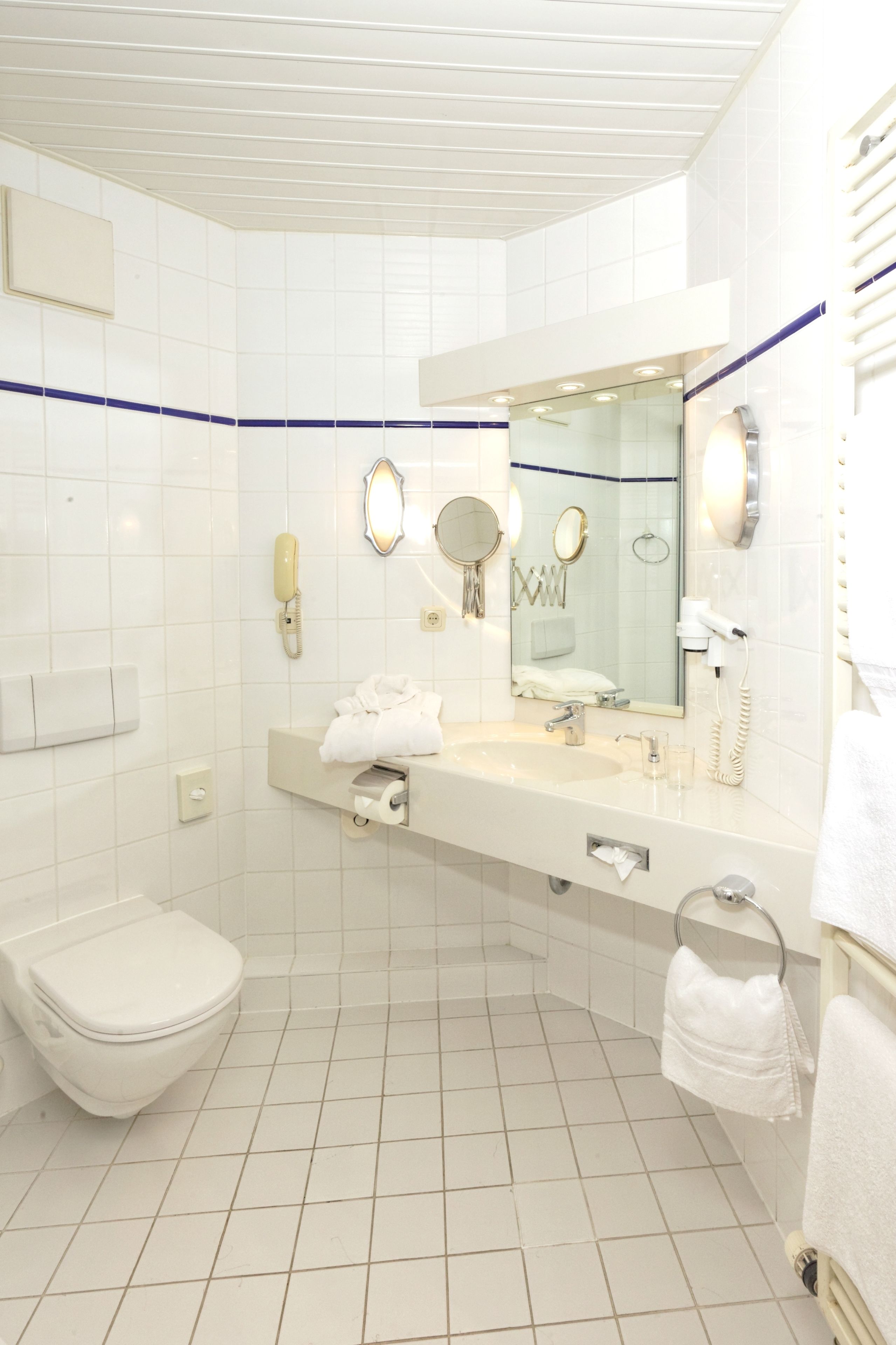 A modern bathroom with a toilet, sink, and mirror.