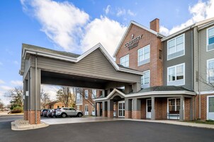 Un hotel con vestíbulo cubierto, fachada de ladrillo y un letrero que indica que es un Radisson Inn & Suites.