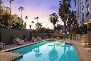 Una piscina al aire libre, sombrillas