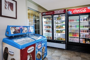 Una máquina expendedora con helado Häagen-Dazs y un refrigerador de Coca-Cola lleno de diversas bebidas.