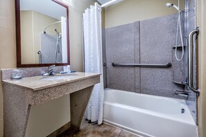 Un baño con bañera, ducha, lavabo y espejo.
