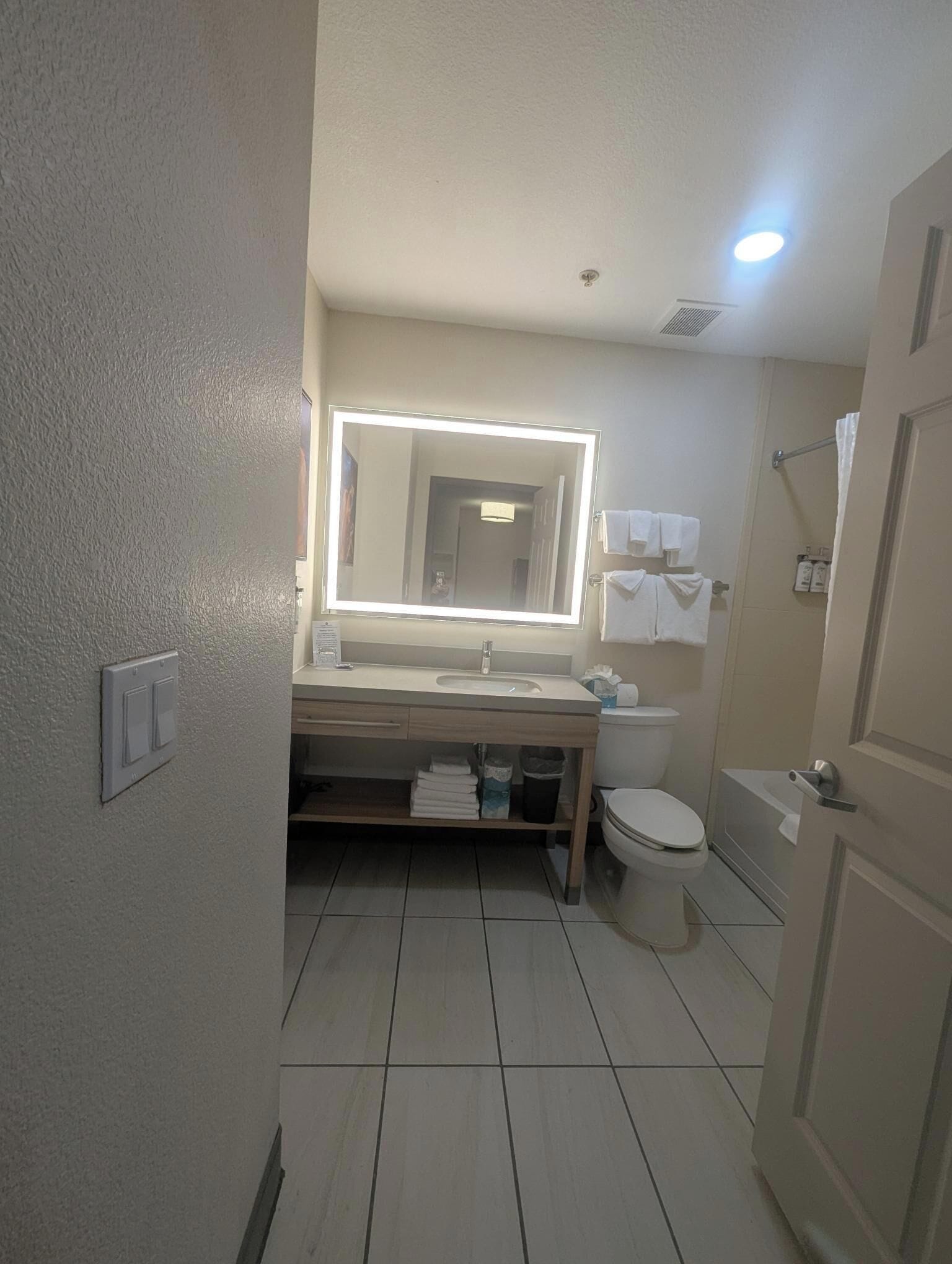 Une salle de bain équipée d’un miroir, d’un lavabo, de toilettes et d’une douche.