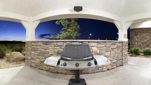 An outdoor grill with a stone wall backdrop and a clear view of the sky. - Candlewood Suites Loveland by IHG (Loveland)