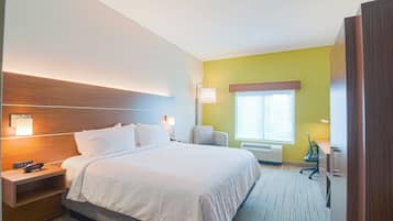 Une chambre d’hôtel avec un lit, une table de chevet, une lampe et une fenêtre.