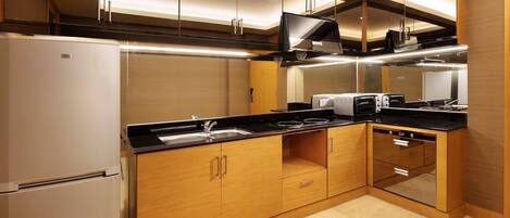 A modern kitchen with wooden cabinets, a built-in oven, and a stainless steel sink.