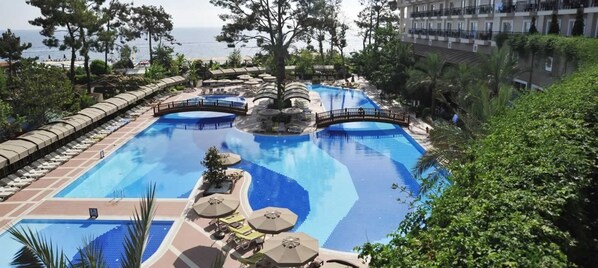 Alberca techada, 3 albercas al aire libre y sombrillas en la alberca