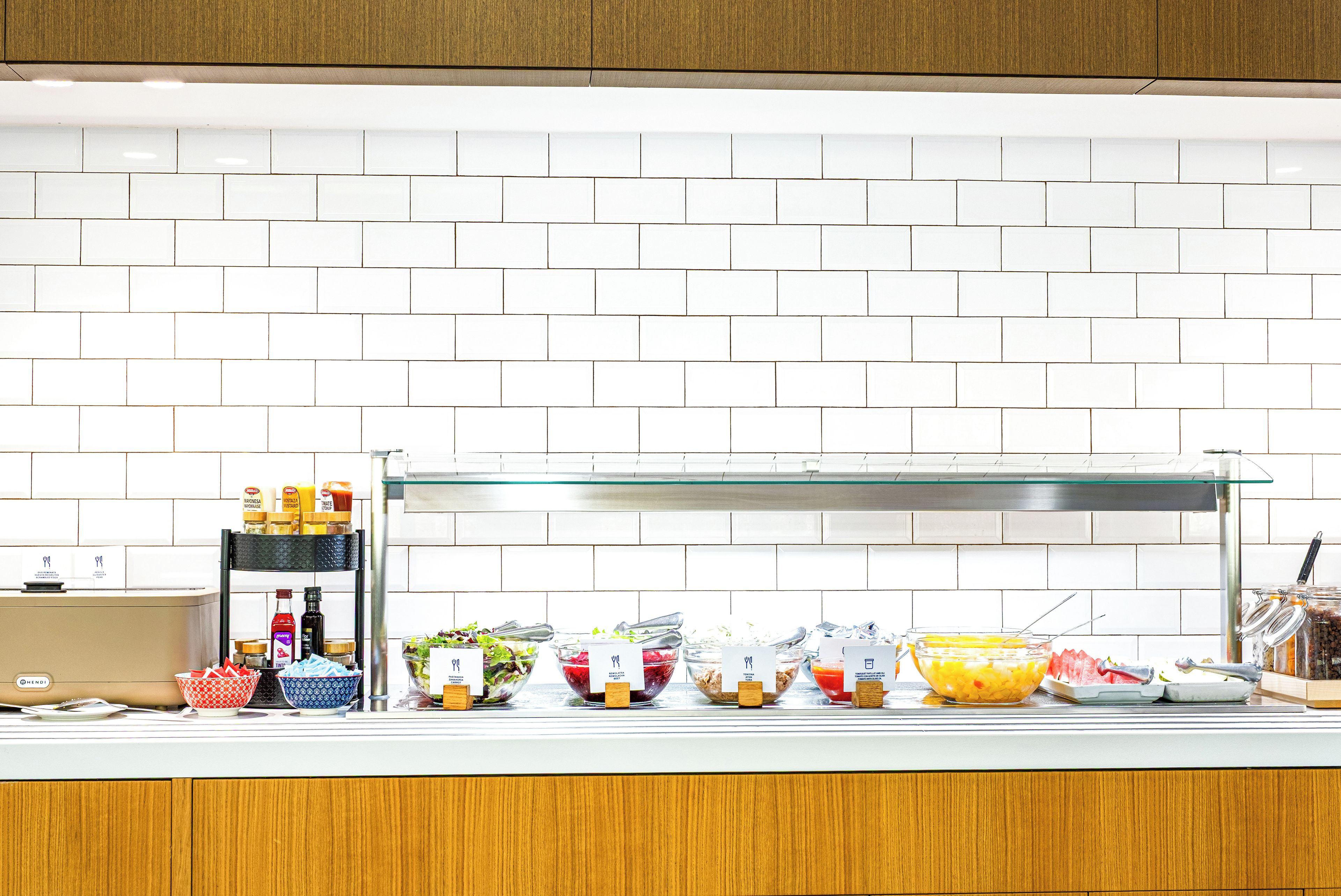 A buffet setup with various food items and condiments.