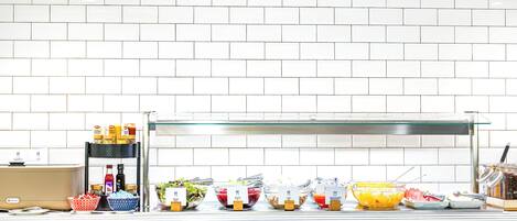 A buffet setup with various food items and condiments.