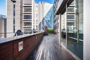 A modern building with a wooden deck, large windows, and a clear sky. - Holiday Inn Express Barcelona City 22@ by IHG (Barcelona)