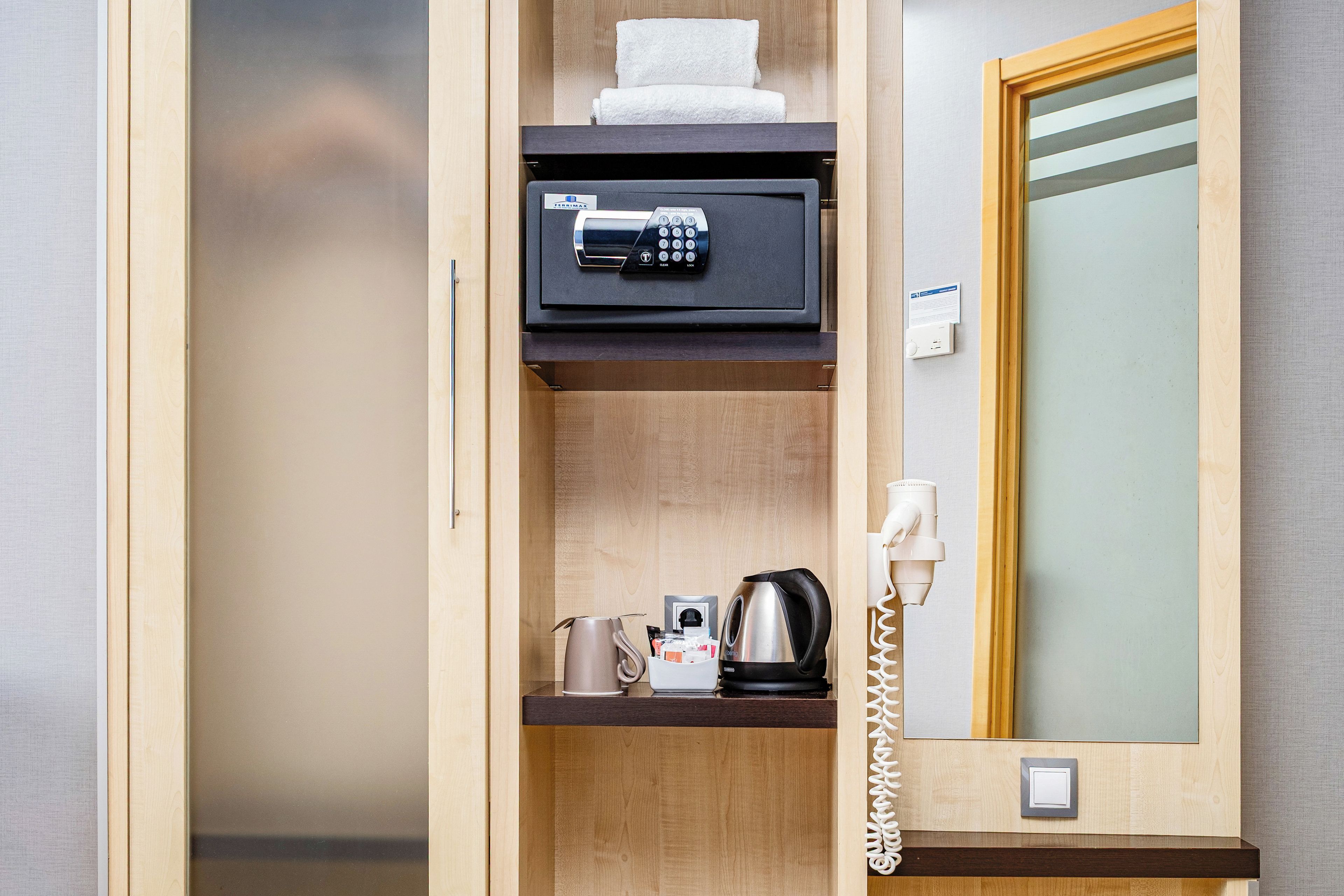 Ein Hotelzimmer mit Minibar, Safe, Wasserkocher und Telefon.