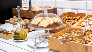 Un buffet amb diversos aliments, incloent pa, pastissos i una gerra de vidre.
