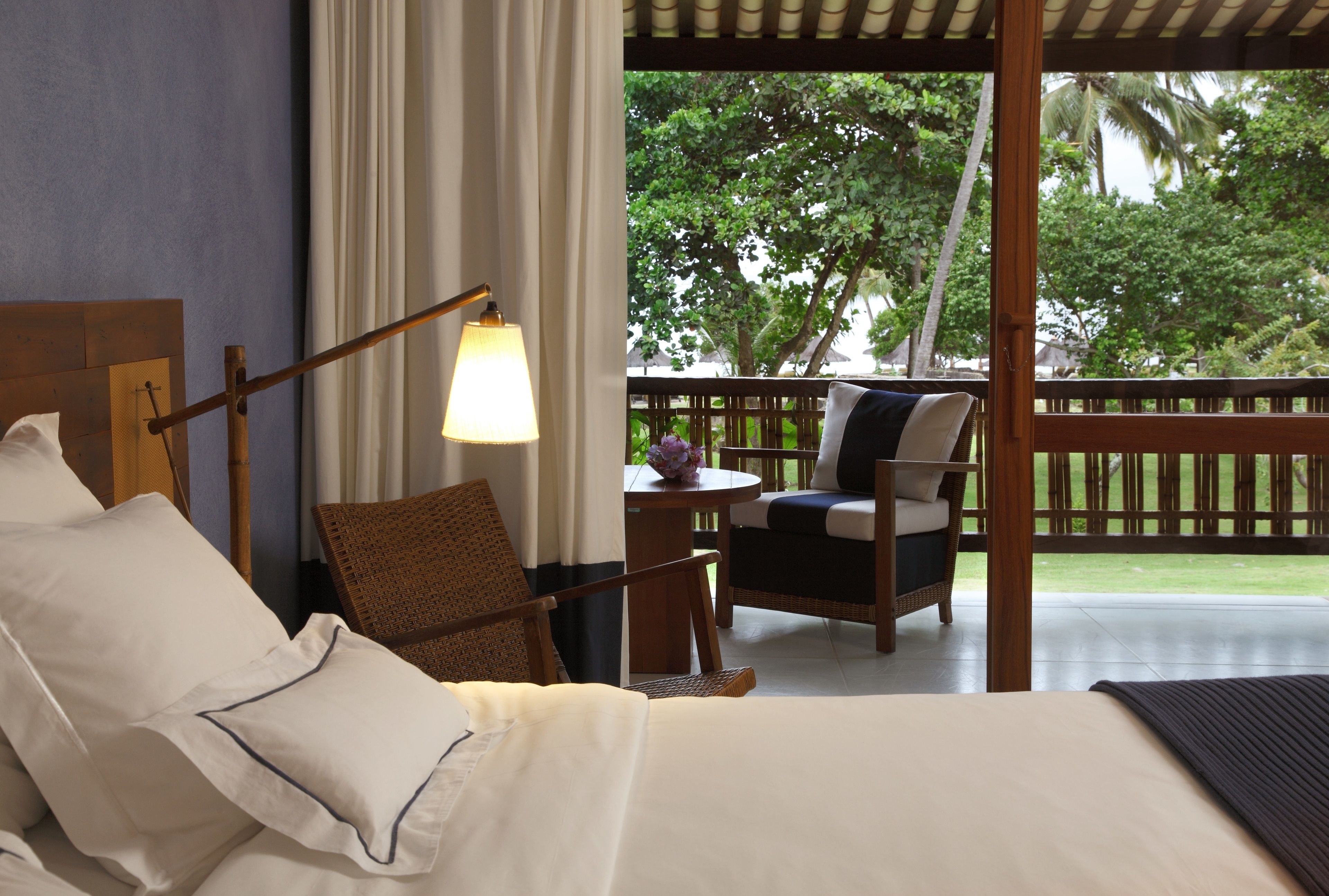 Habitación de hotel con cama, una silla, una mesa y vistas al exterior.