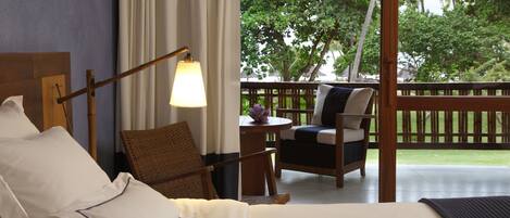 Habitación de hotel con cama, una silla, una mesa y vistas al exterior.
