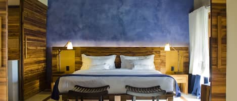 Un dormitorio con una cama grande, dos lámparas de noche y un cabecero de madera.