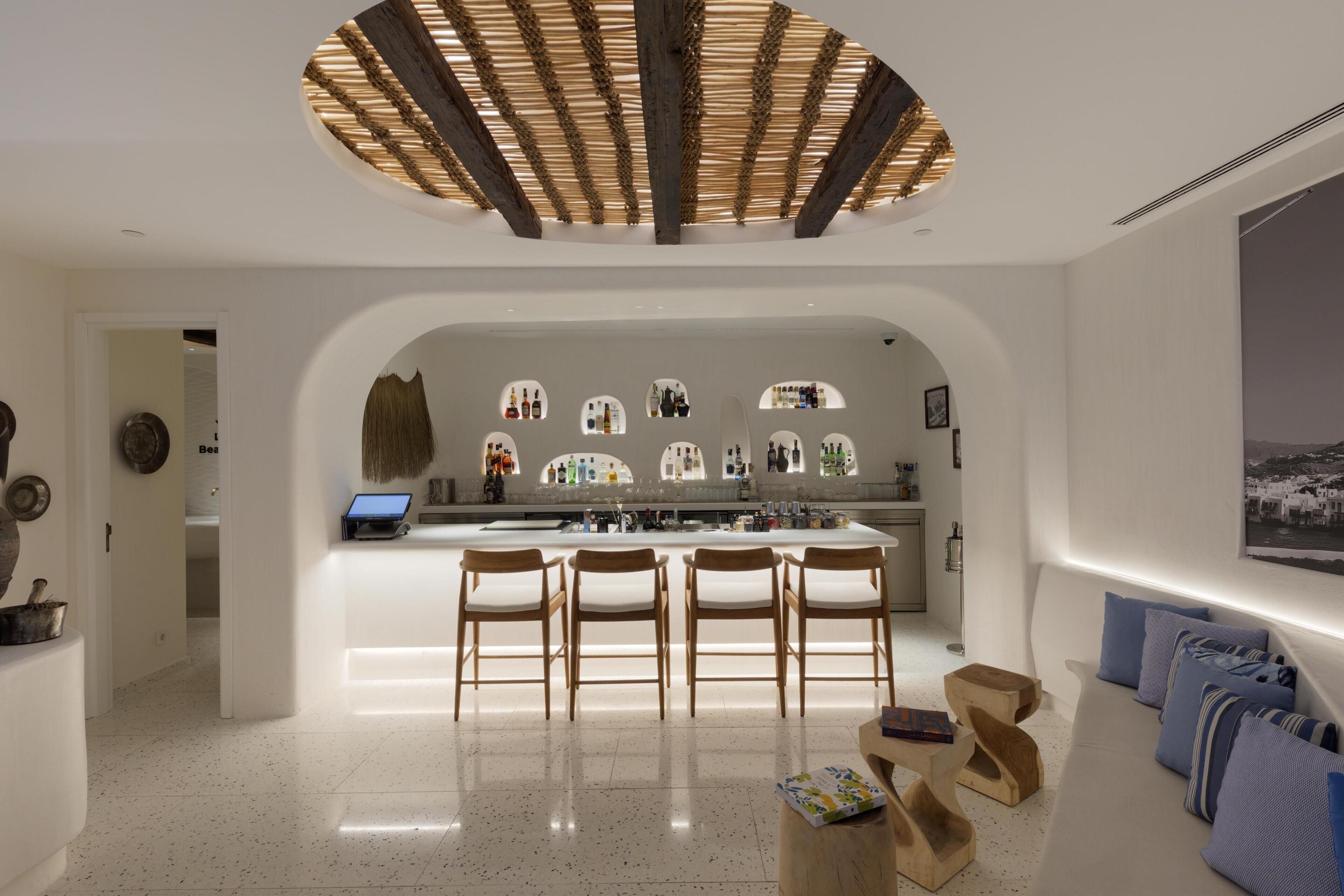Una cocina moderna con una isla central, sillas de madera y un ordenador portátil sobre la isla.