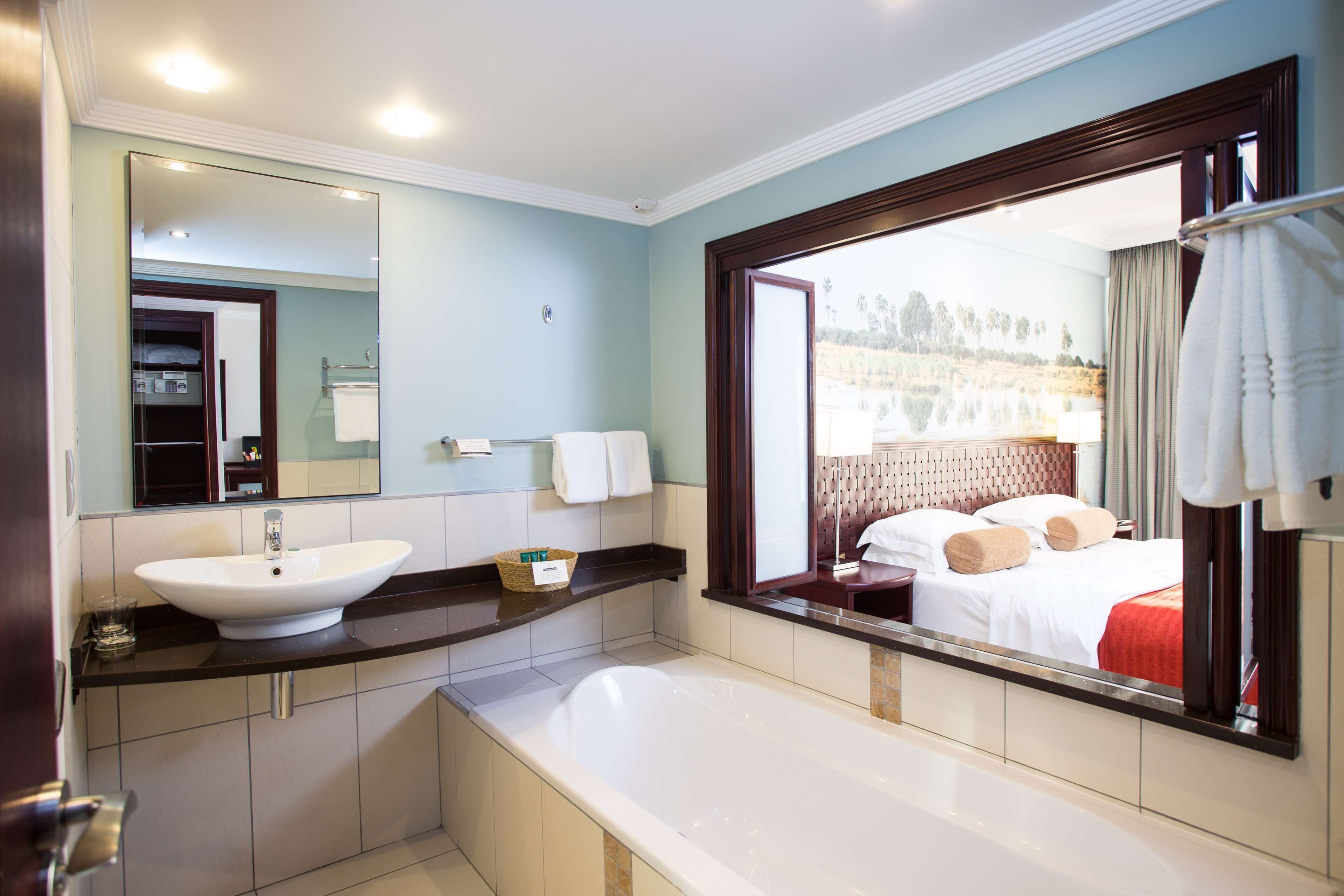 Ein modernes Badezimmer mit einer großen Badewanne, einem Waschbecken und einem Spiegel.