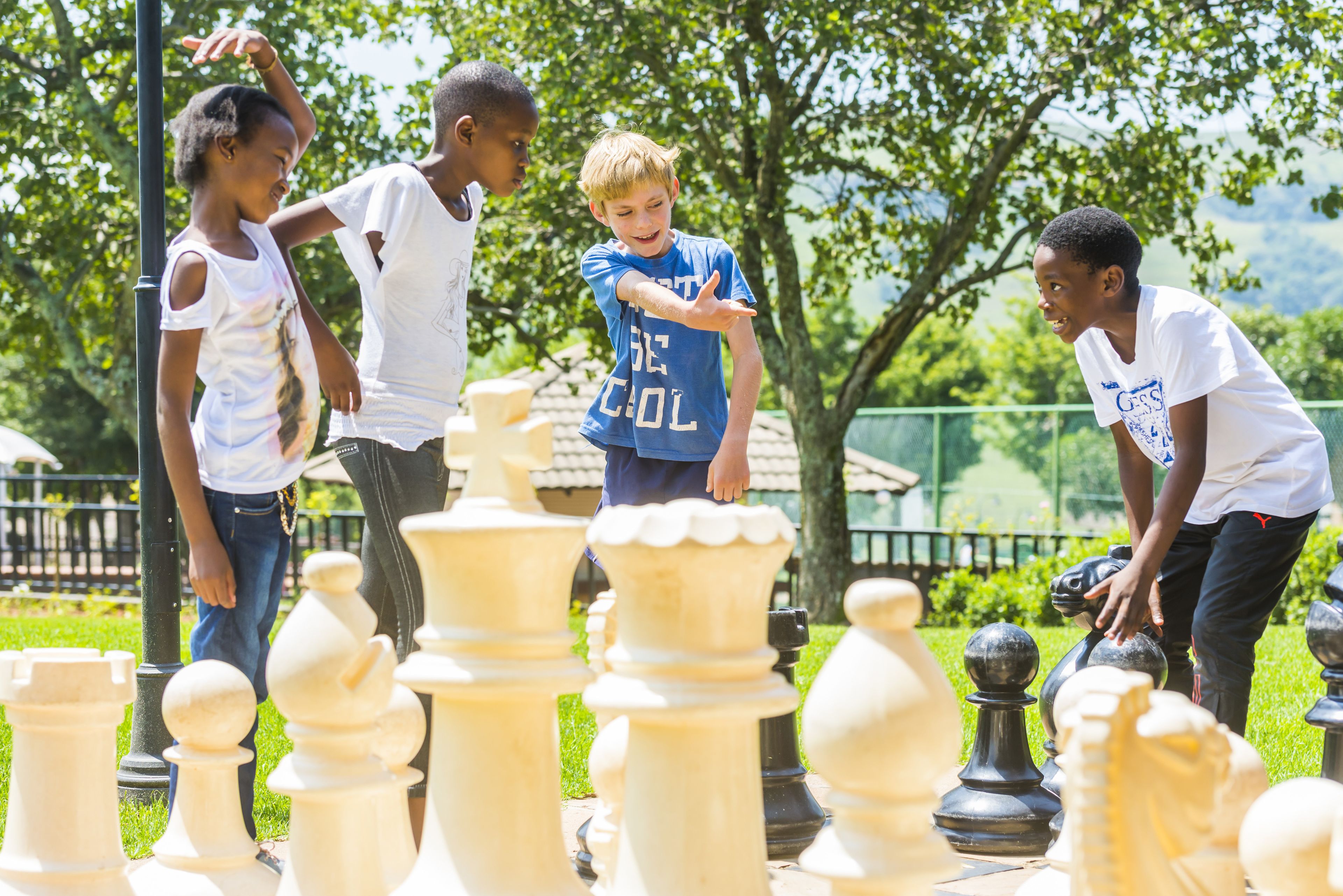 A group of people playing chess outdoors.