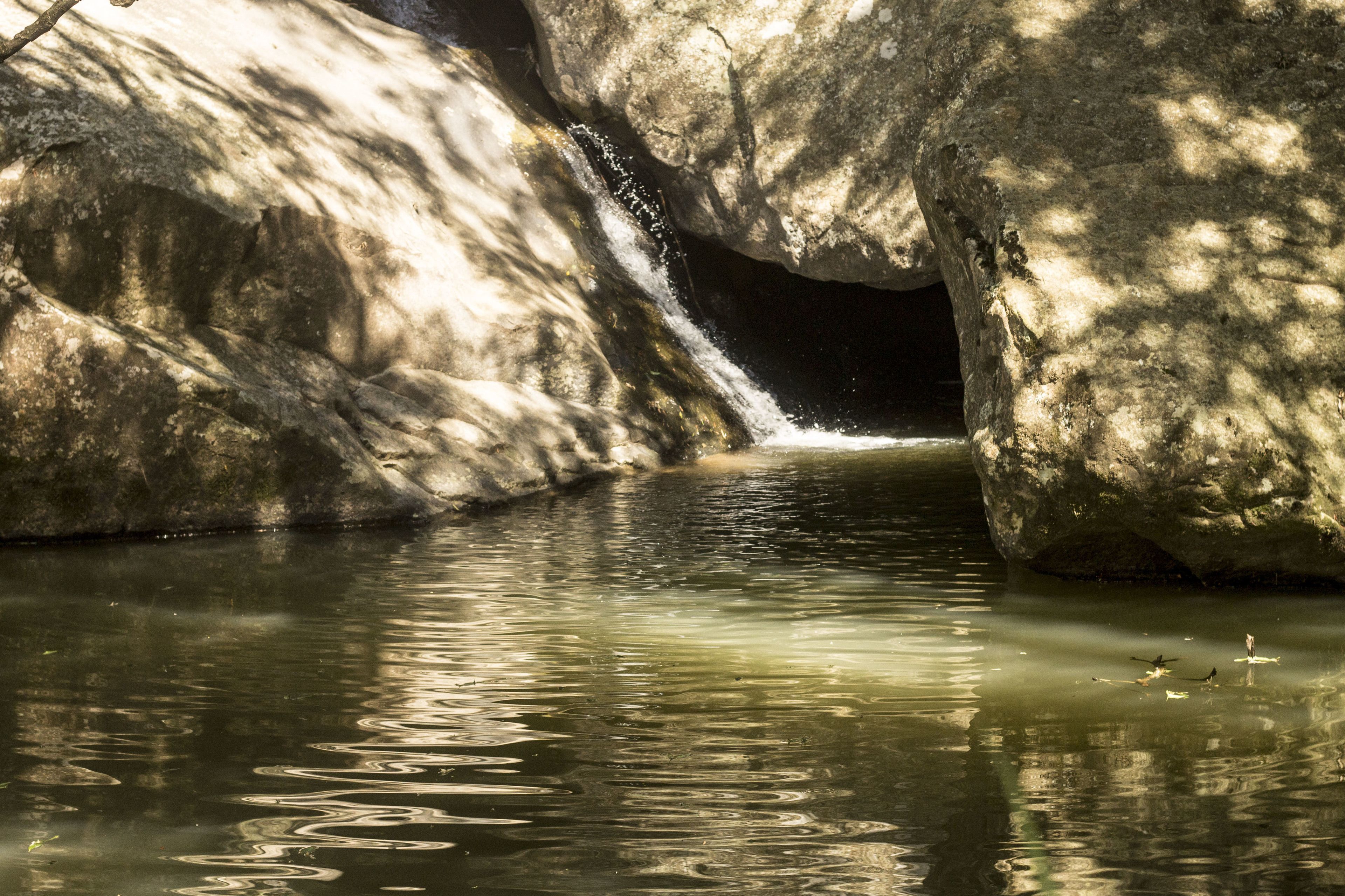 A natural rock formation with a small waterfall.