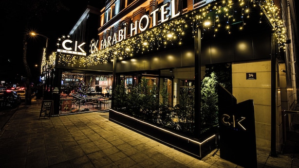 A hotel exterior at night with illuminated signage and a well-lit entrance. - CK Farabi Hotel (Ankara)