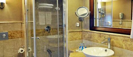 Un baño moderno con ducha envuelta en vidrio, lavamanos y retrete.