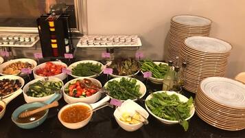 A buffet with various food items and condiments.
