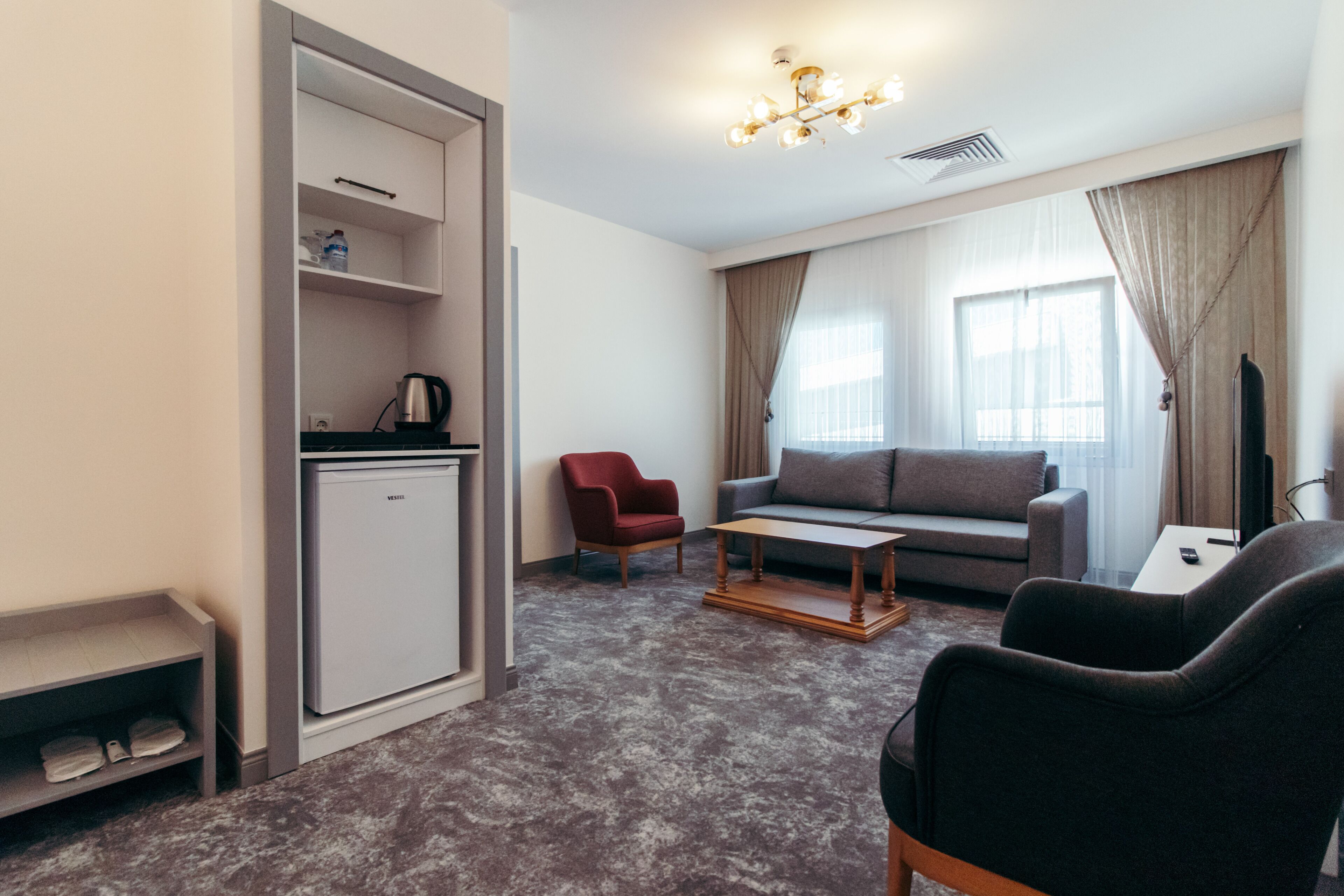 A compact living space with a kitchenette, a sofa, a coffee table, and a TV.
