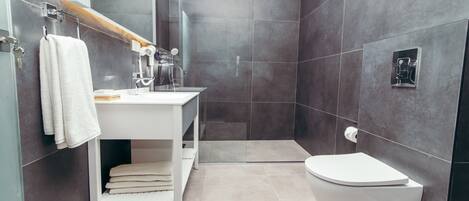 Ein modernes Badezimmer mit einem weißen Waschtisch, einer Toilette und einer Duschkabine.