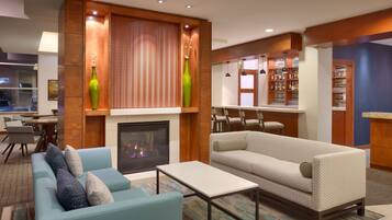 Una sala de estar moderna con chimenea, dos sofás, una mesa de centro y una estantería.